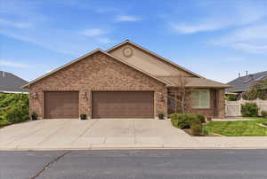 Ranch-style house featuring brick siding, a garage, and driveway