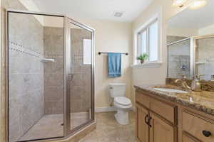 Bathroom with vanity, a stall shower, and light tile patterned flooring