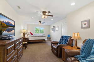 Bedroom featuring dark carpet, ceiling fan, and recessed lighting