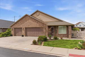 Single story home with brick siding, a garage, and concrete driveway
