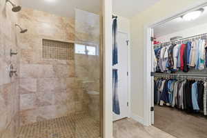 Bathroom featuring walk in shower and a spacious closet