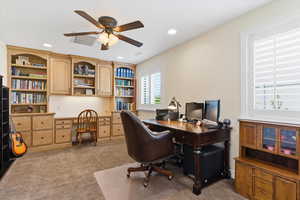 Home office with light colored carpet, a ceiling fan, recessed lighting, and built in desk