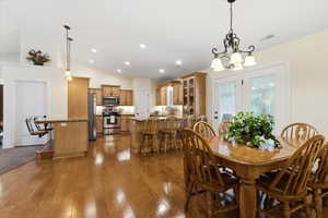 Dining room with vaulted ceiling, dark wood-style flooring, and a chandelier