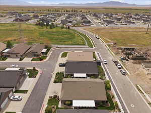Aerial view of property and surrounding area featuring nearby suburban area and a mountainous background