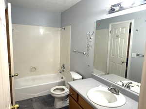 Bathroom featuring vanity, bathtub / shower combination, and dark tile patterned flooring