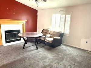 Living area featuring carpet flooring and a tiled fireplace