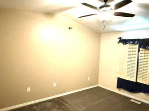 Master room featuring lofted ceiling, ceiling fan, and dark carpet