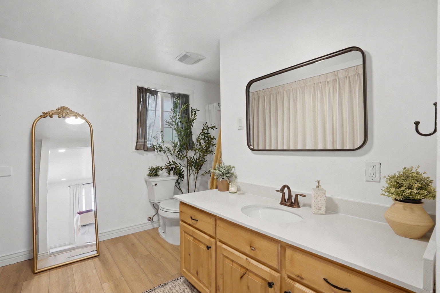 Bathroom with a wood-finish vanity, white countertop, and integrated sink