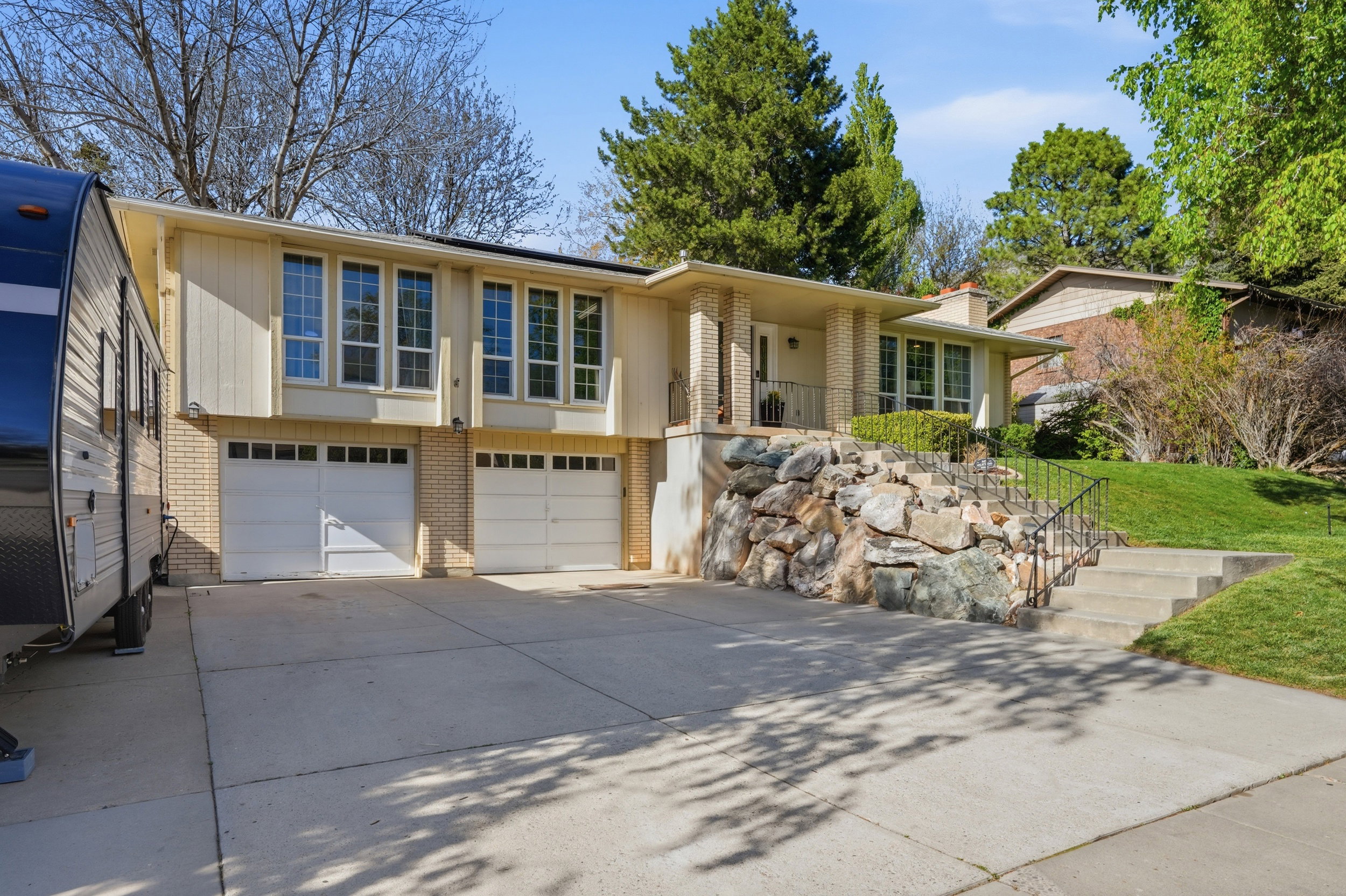 View of front facade with brick siding, a garage, and driveway