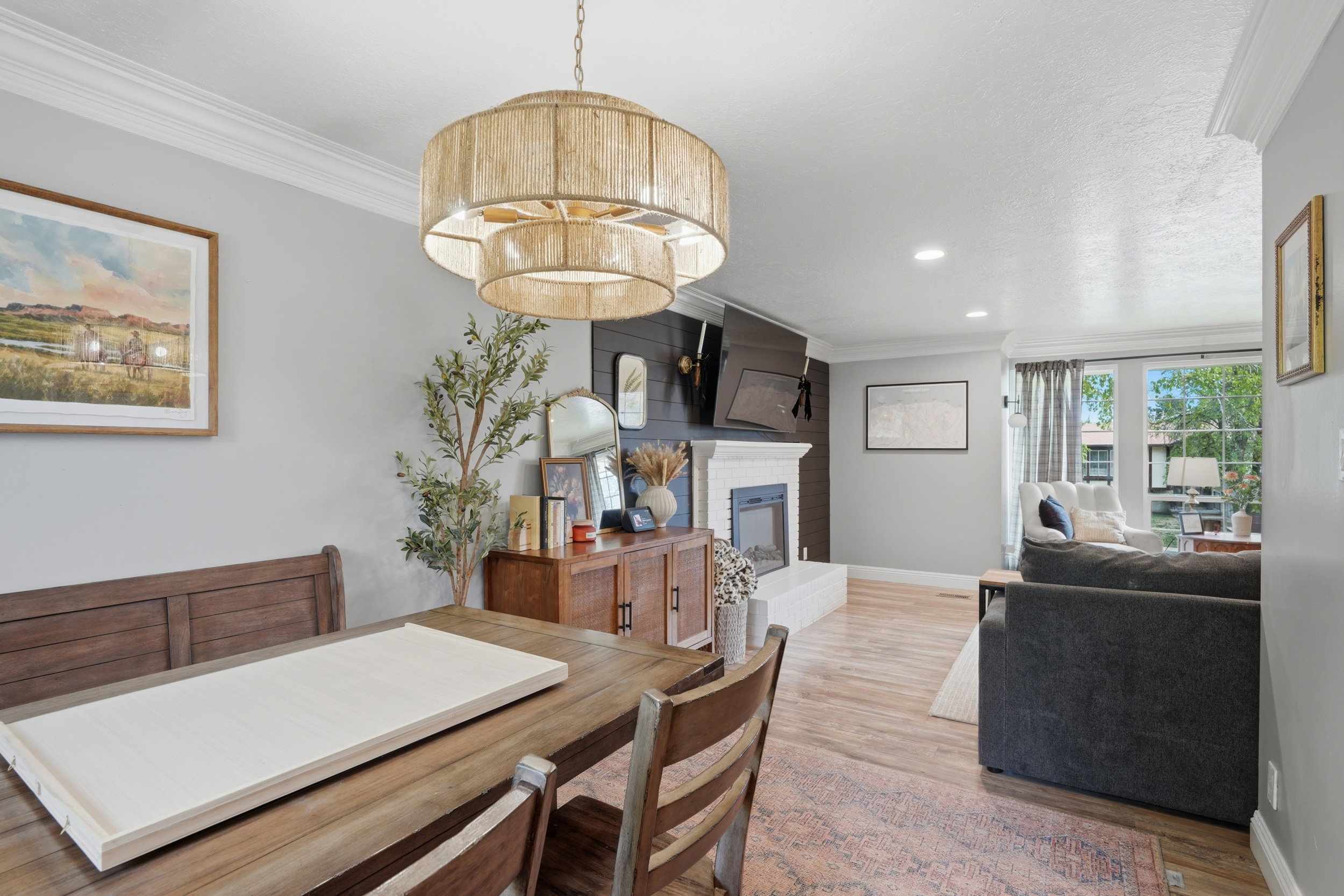 Dining area with ornamental molding, light wood-type flooring, a fireplace, and recessed lighting