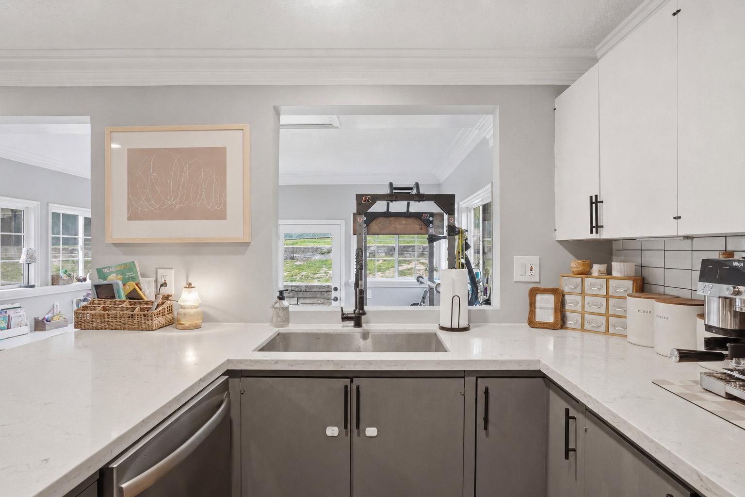 Contemporary kitchen with white countertops and contrasting gray lower cabinetry, complemented by white upper cabinets