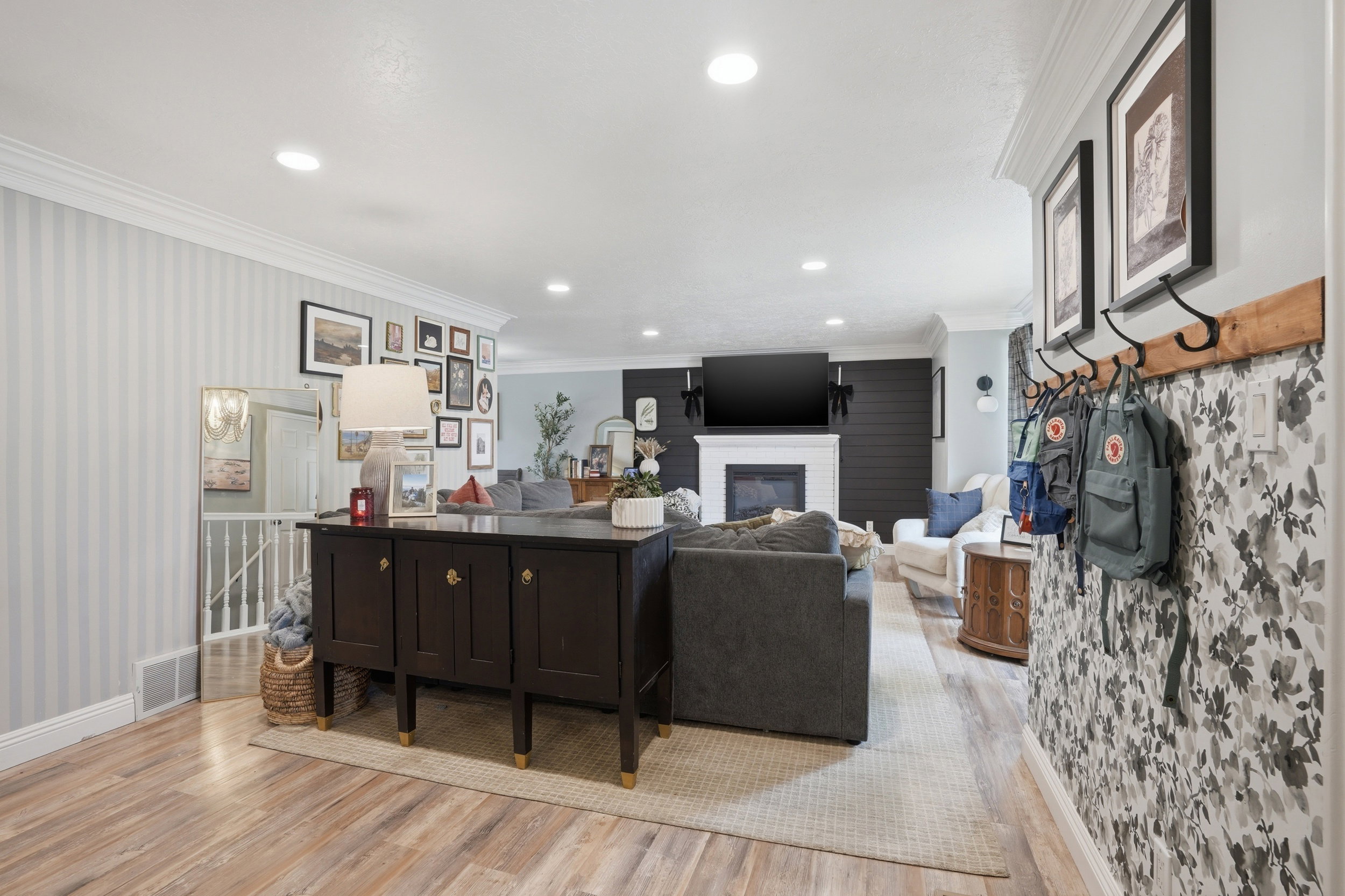Living room featuring ornamental molding, recessed lighting, light wood finished floors, a brick fireplace, and wallpapered walls