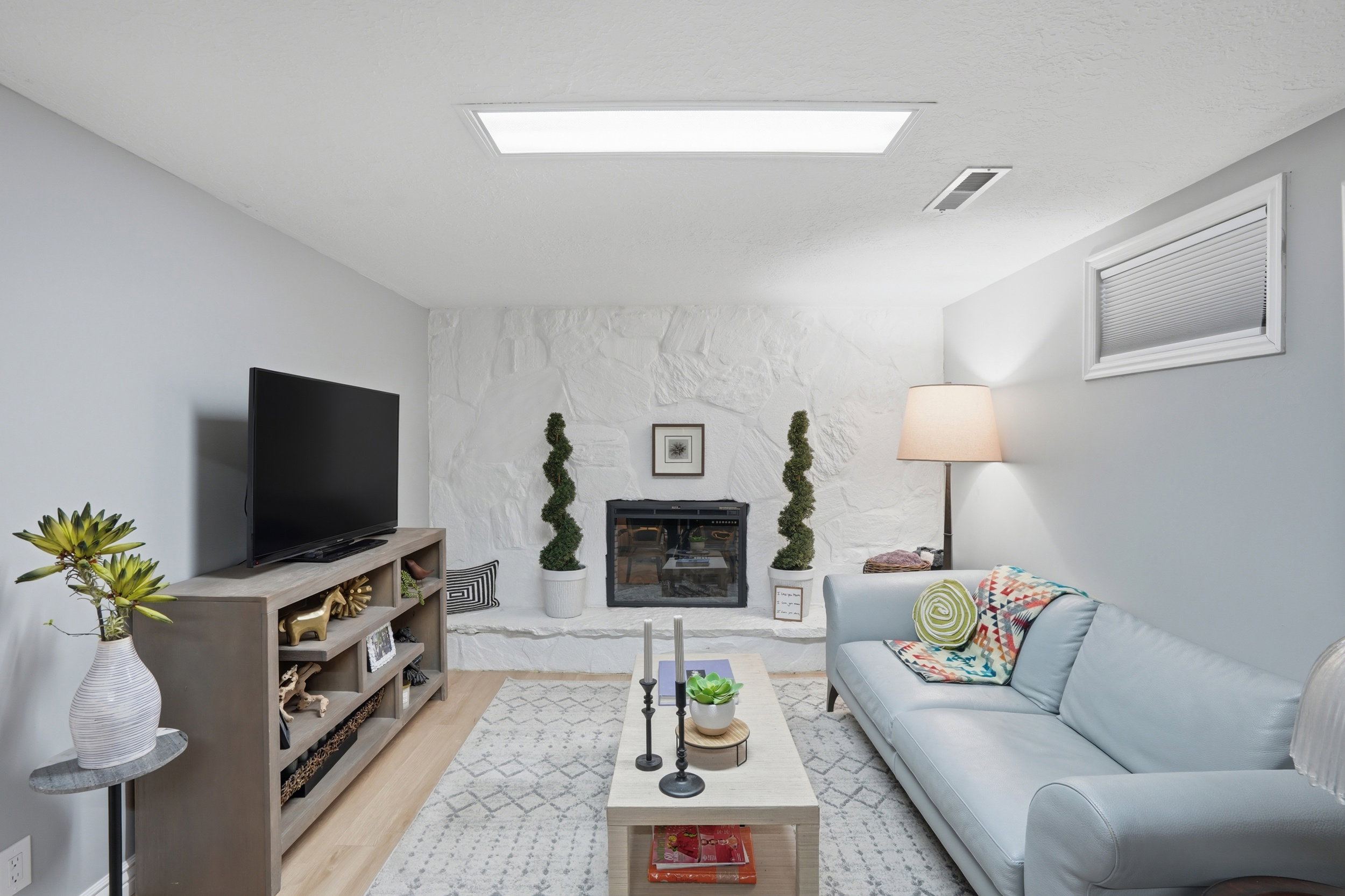 Living area featuring light wood-style flooring and a stone fireplace