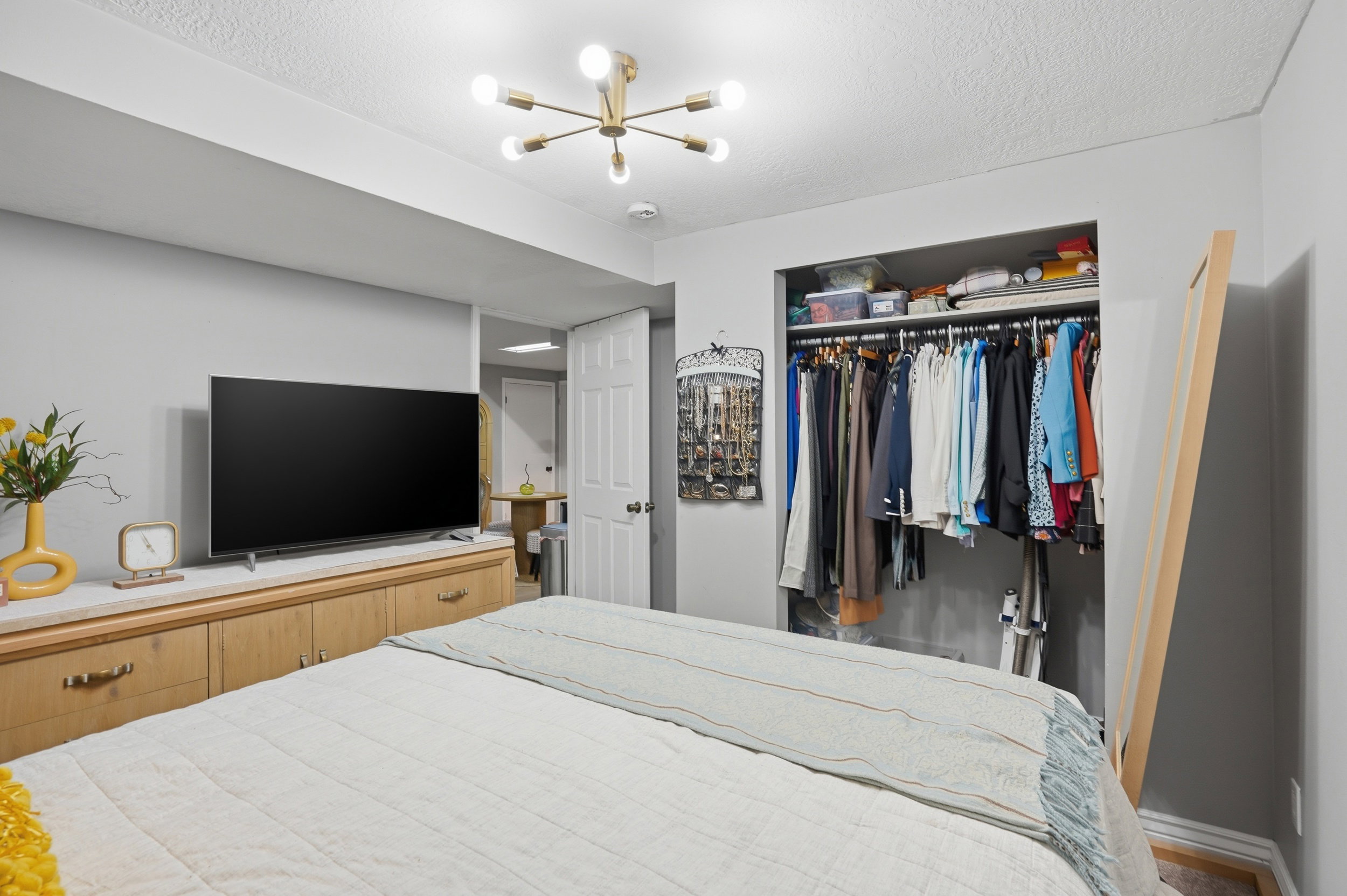 Bedroom with a closet, a textured ceiling, and suspended lighting