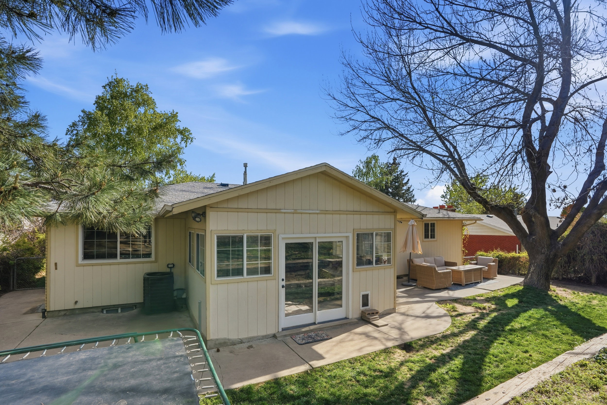 Back of house featuring a patio area, outdoor seating, and roof with shingles