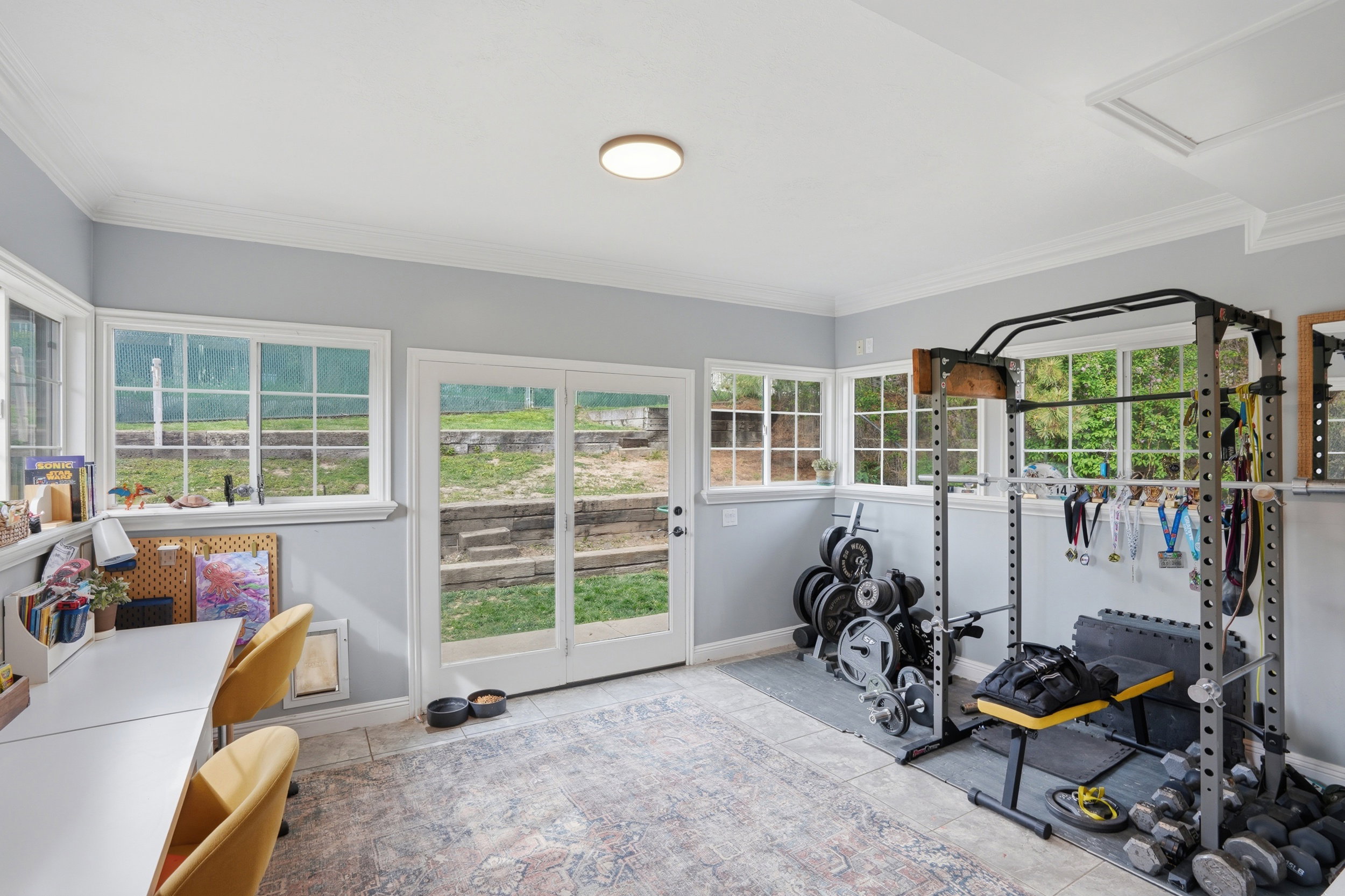 Sunroom featuring light tile patterned floors and crown molding