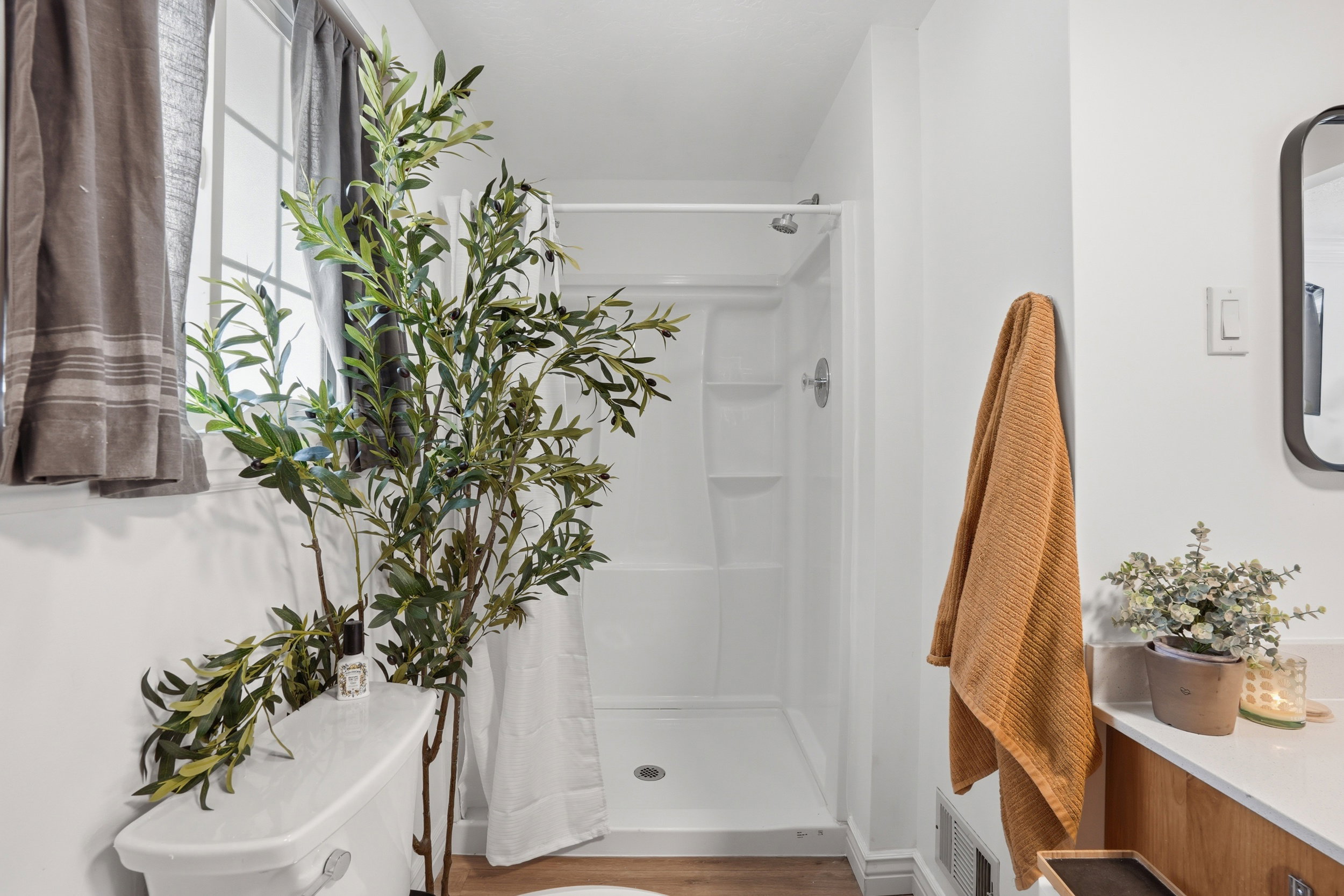 Full bathroom featuring a stall shower and light wood finished floors