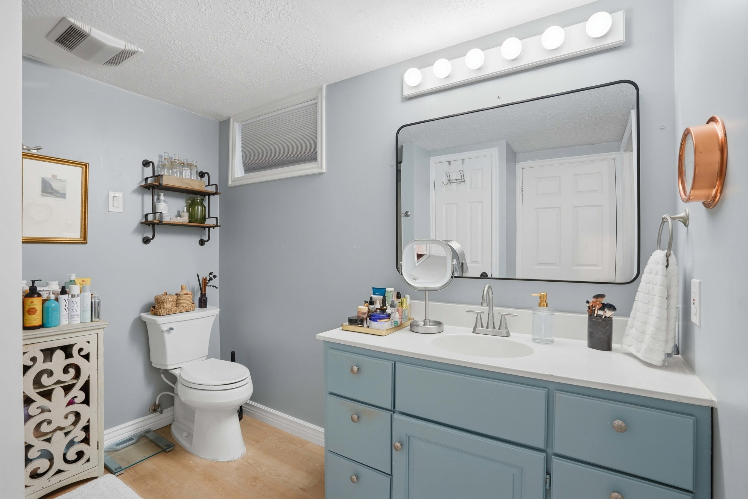 Bathroom featuring vanity, light wood-style flooring, and a textured ceiling
