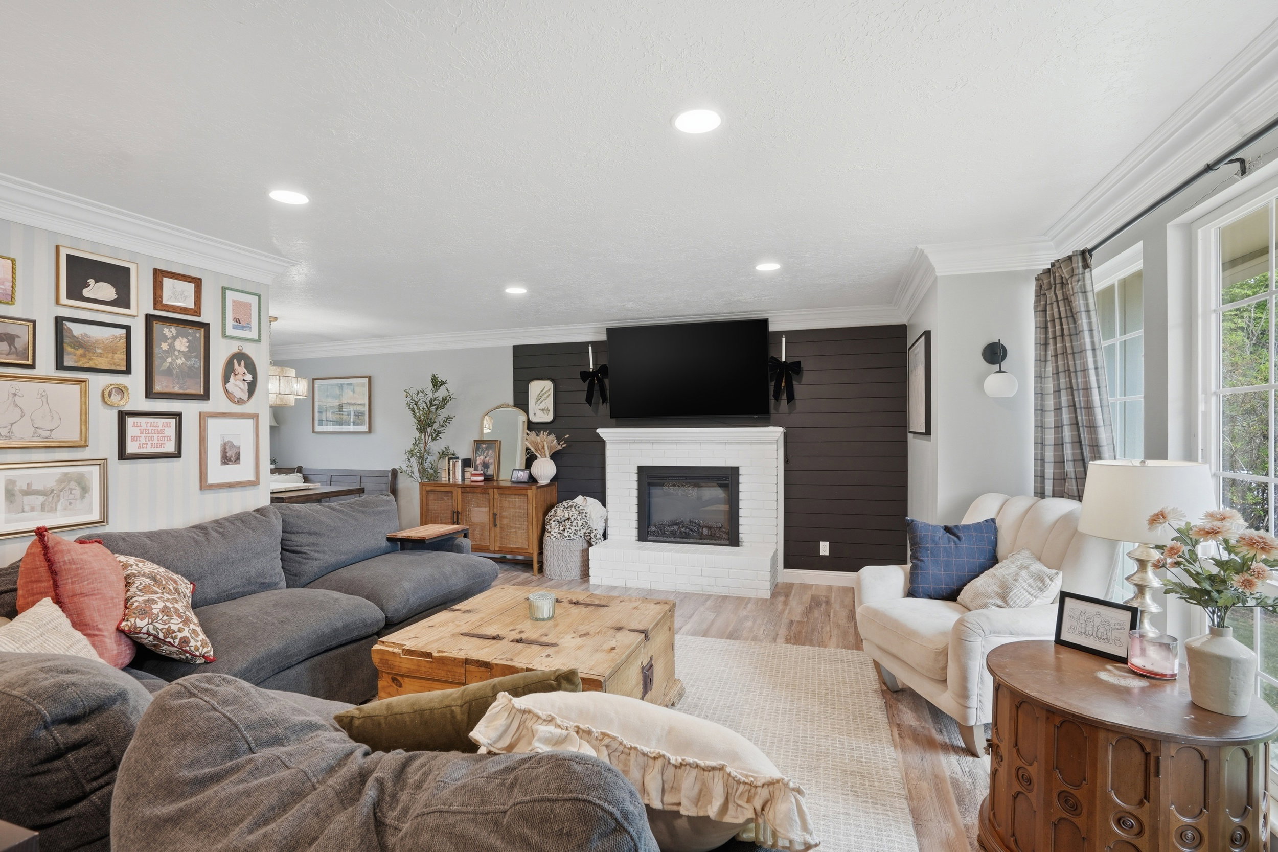 Living room featuring wood finished floors, a fireplace, crown molding, and recessed lighting