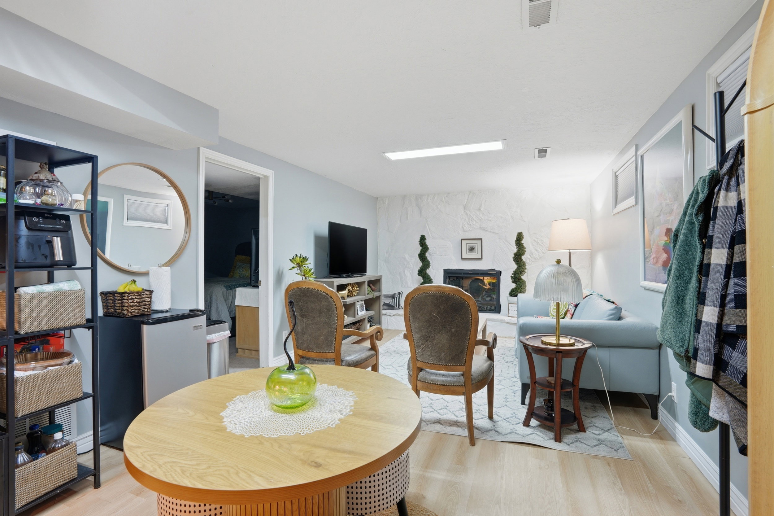 Dining space with light wood-type flooring and a stone fireplace