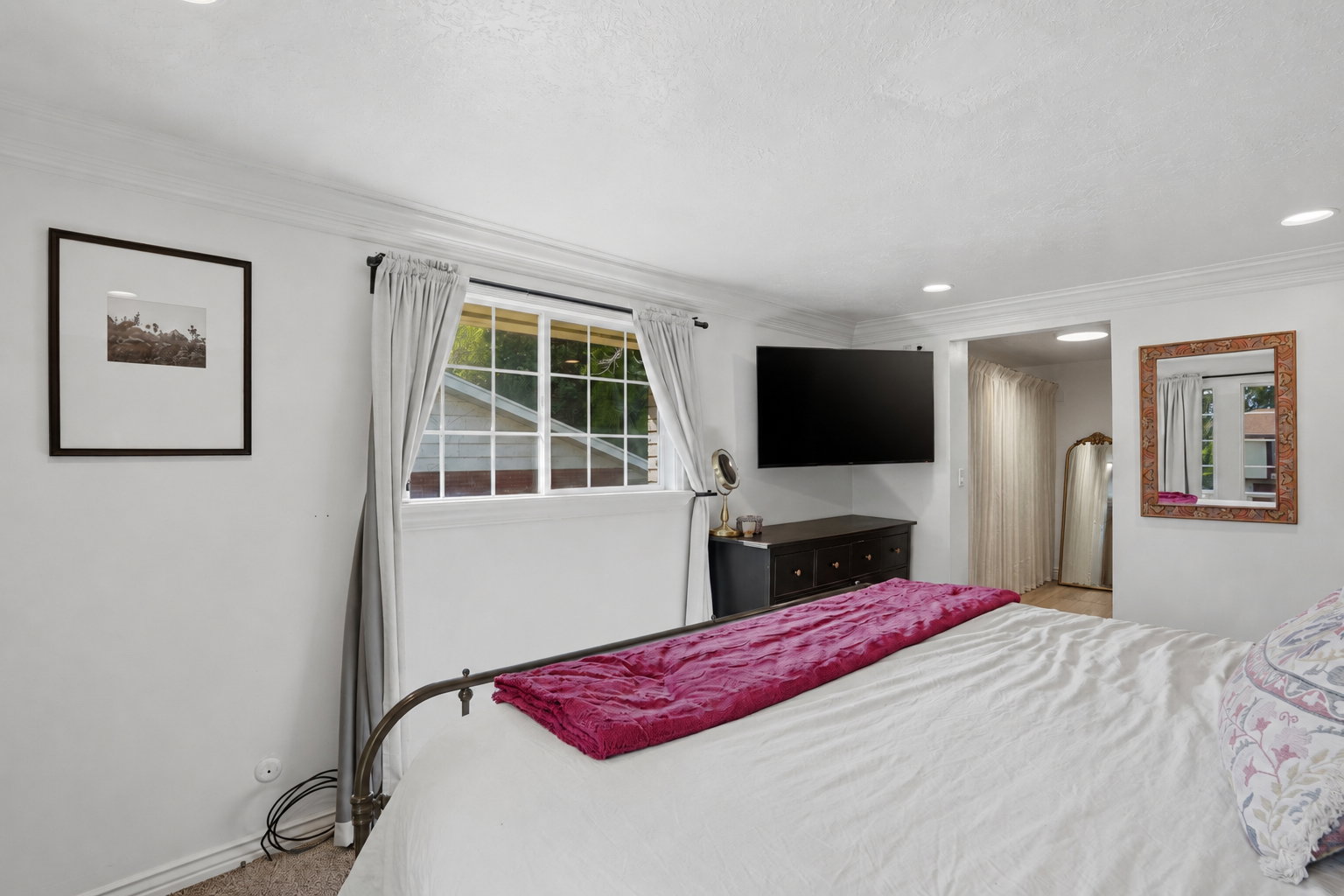 Interior space featuring white walls, crown molding, recessed lighting, and a multi-pane window