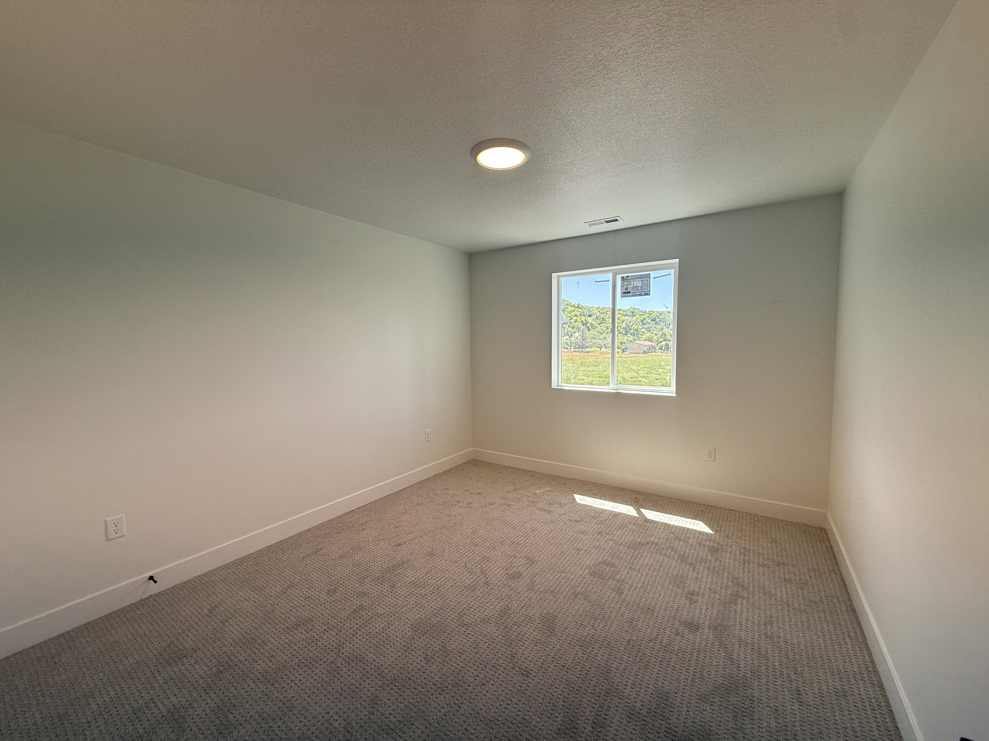 Carpeted room with a single pane window, recessed lighting, and white baseboards