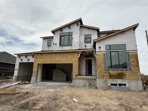 View of front of property with an attached garage and stucco siding
