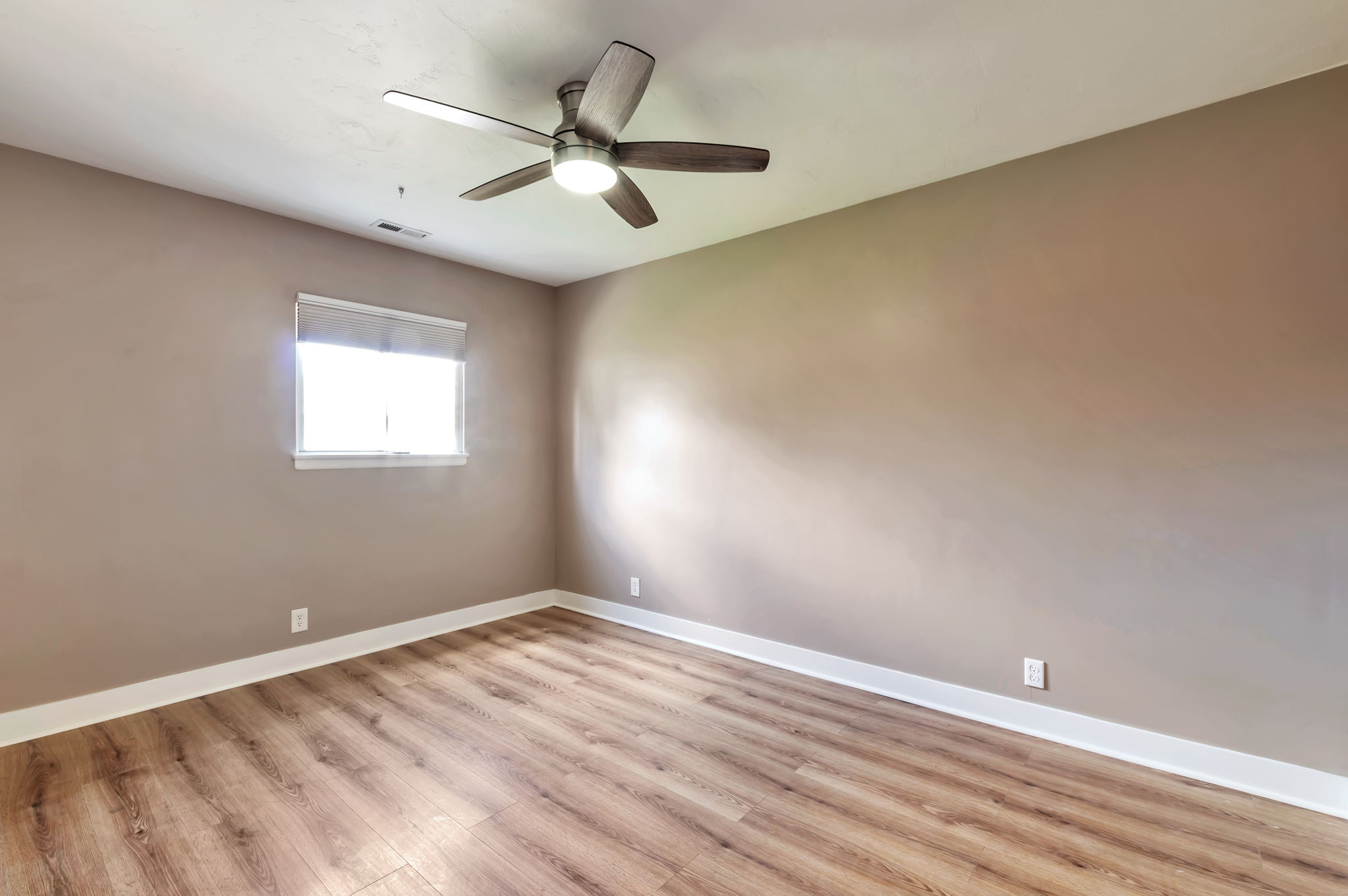 Spare room featuring light wood-style floors and a ceiling fan