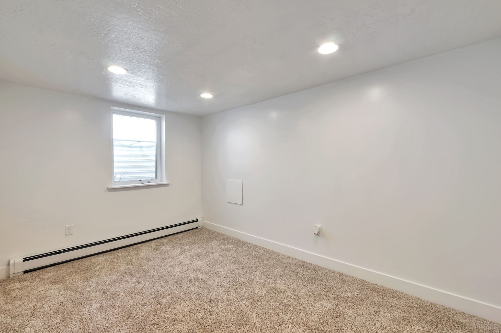 Spare room with baseboard heating, carpet flooring, and recessed lighting