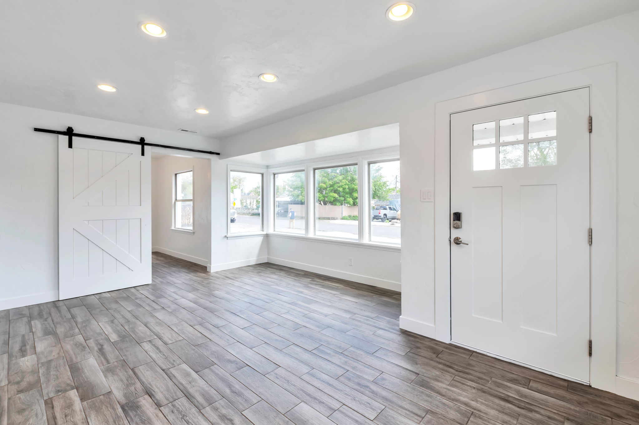 Foyer featuring a barn door, wood finish floors, and recessed lighting