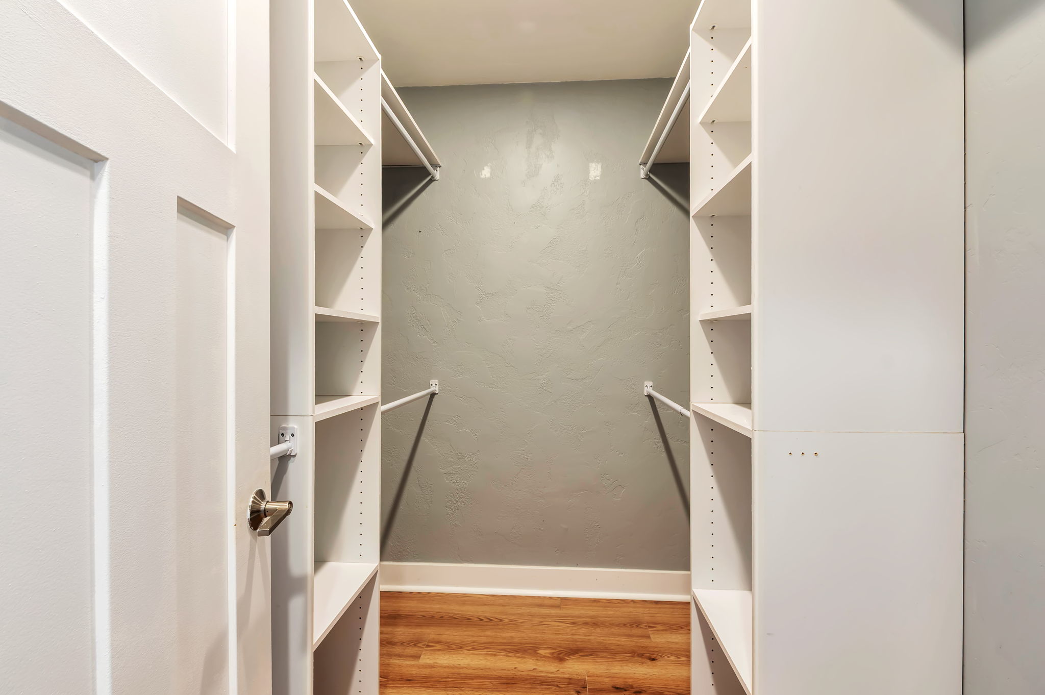 Walk in closet with light wood-style floors