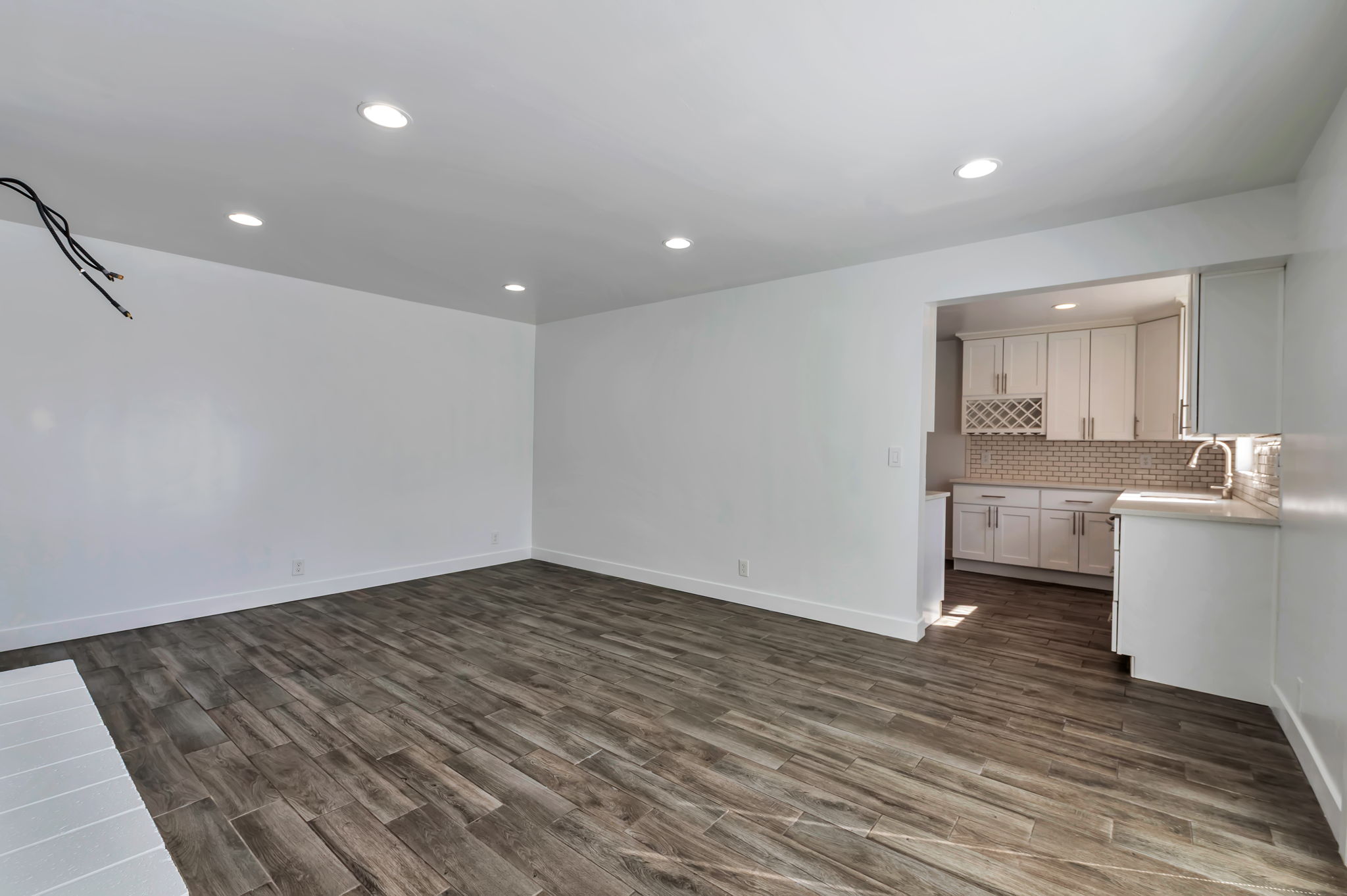 Unfurnished living room with dark wood-type flooring and recessed lighting