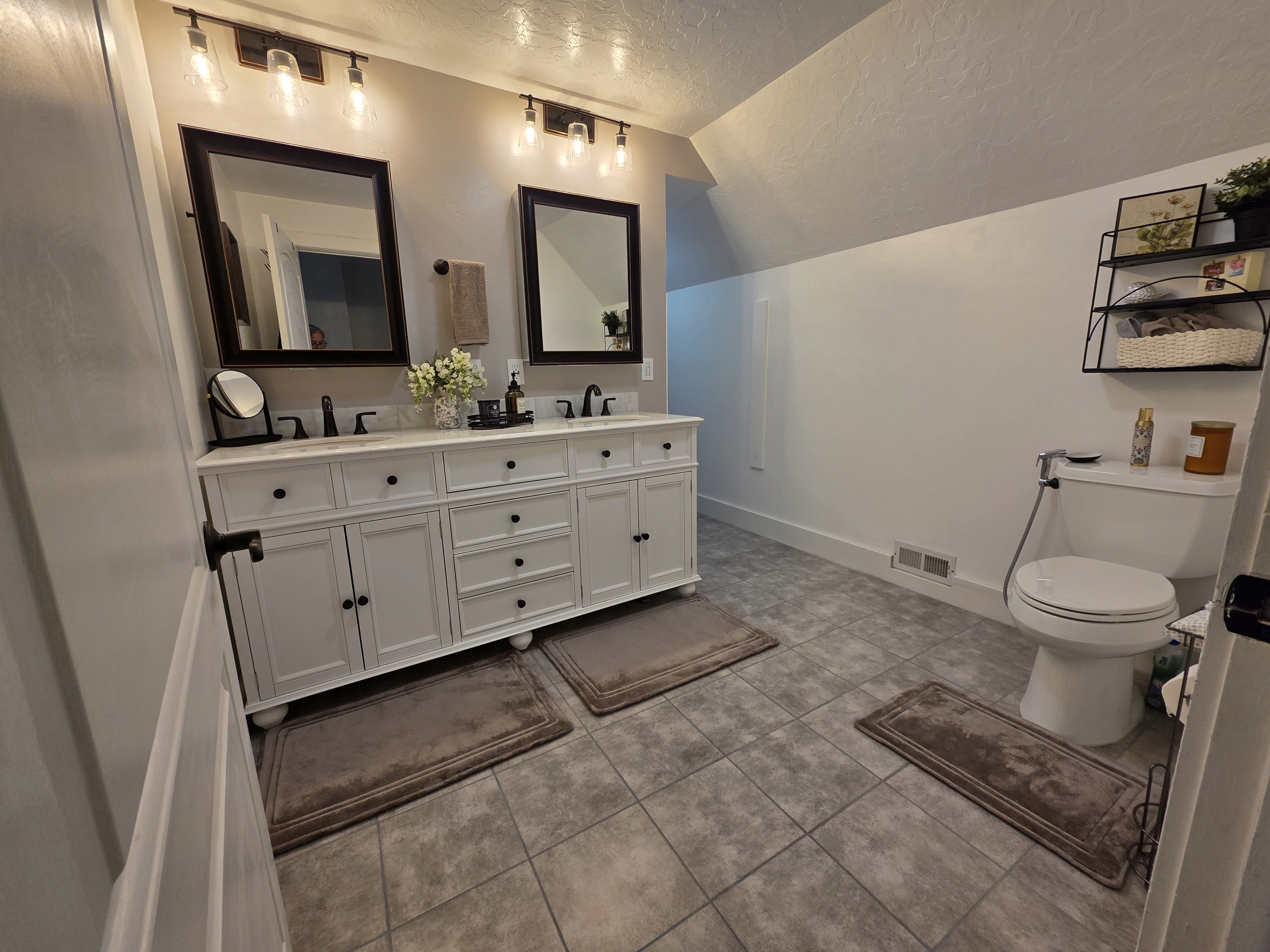 Bathroom with double vanity and light tile patterned floors