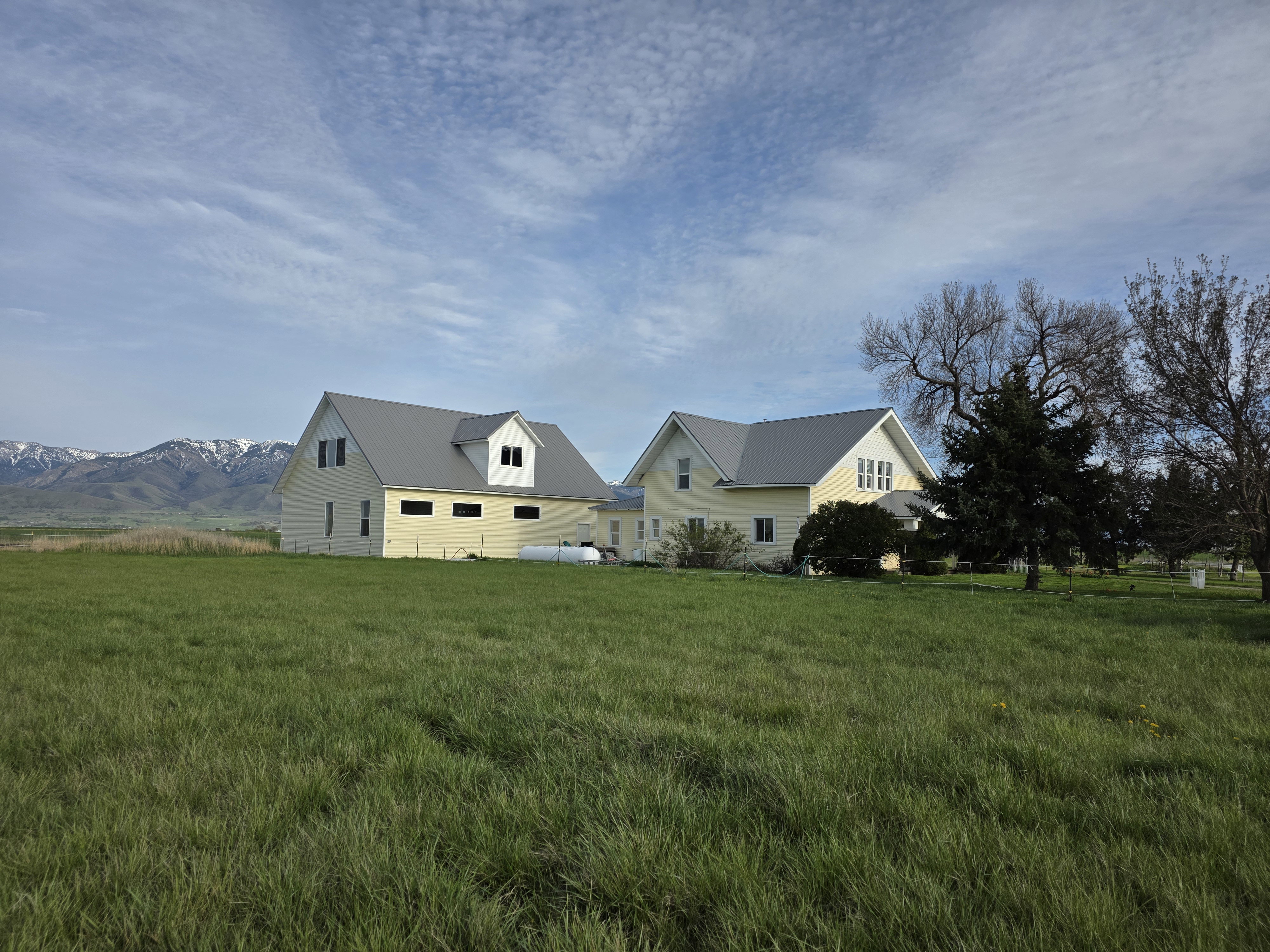 View of front facade featuring a front lawn, a metal roof, and a mountain view