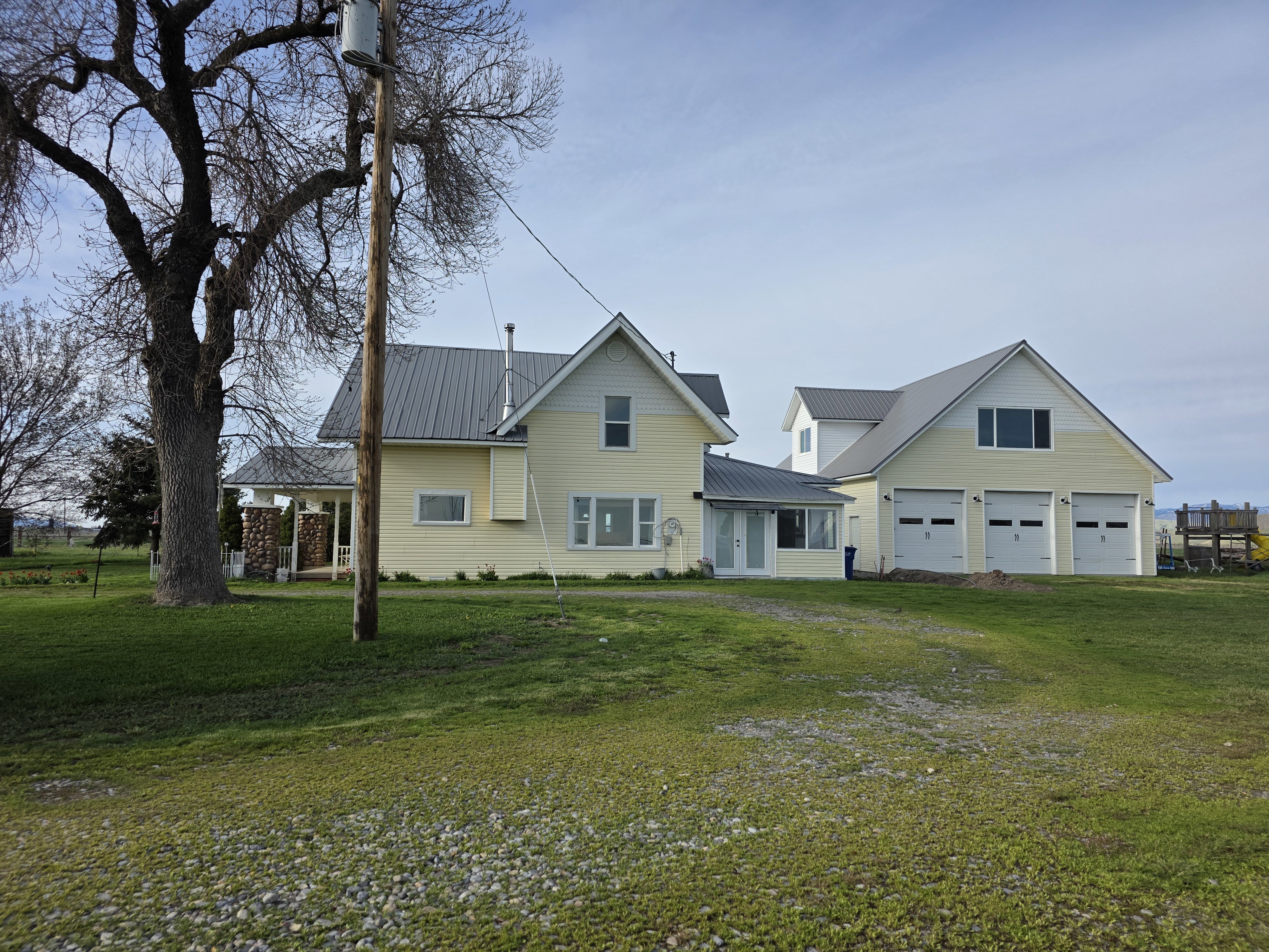 Traditional-style home featuring a metal roof, a garage, a front lawn, and driveway