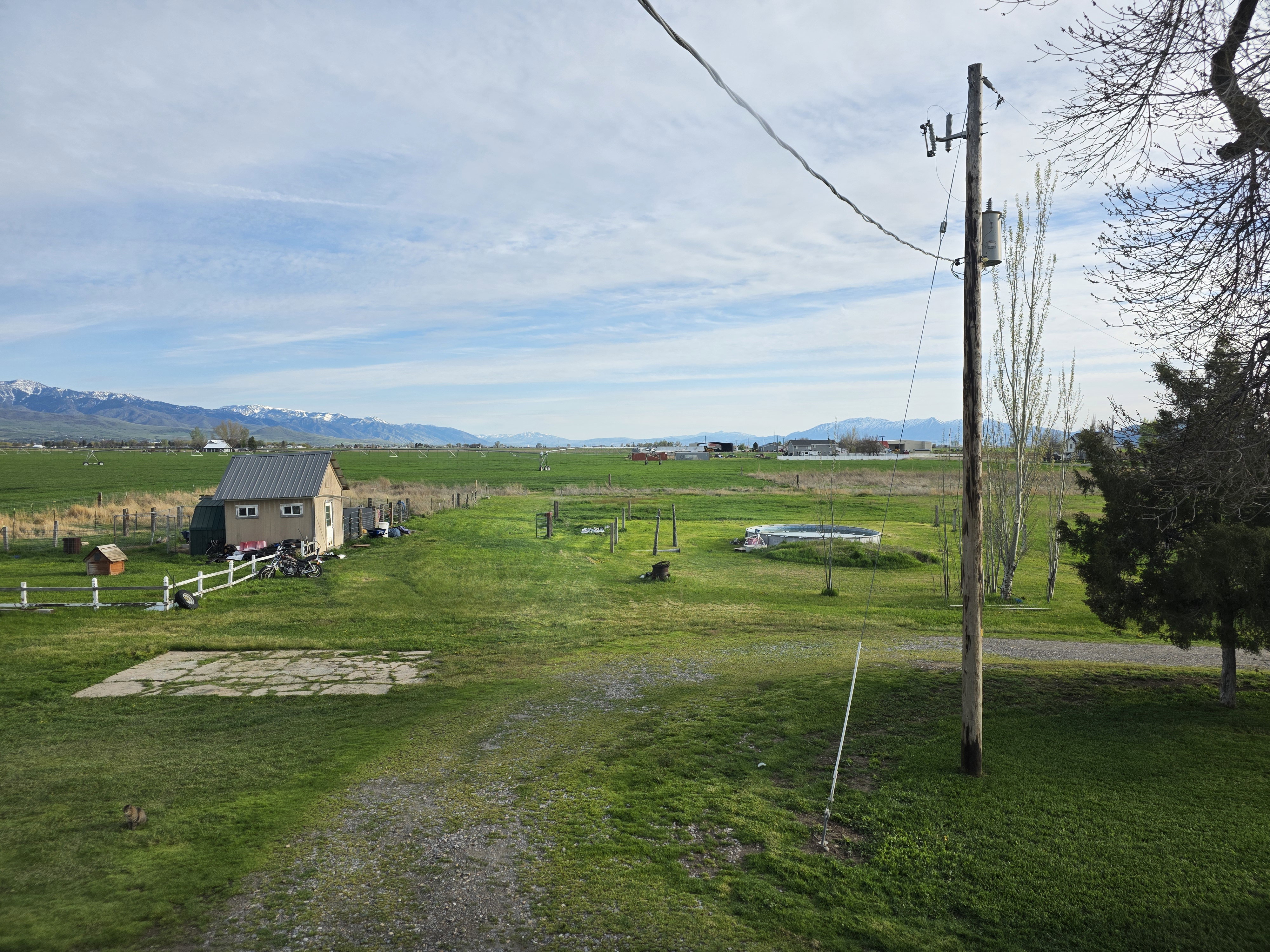 View of green lawn featuring a rural view, an outbuilding, and a mountain view