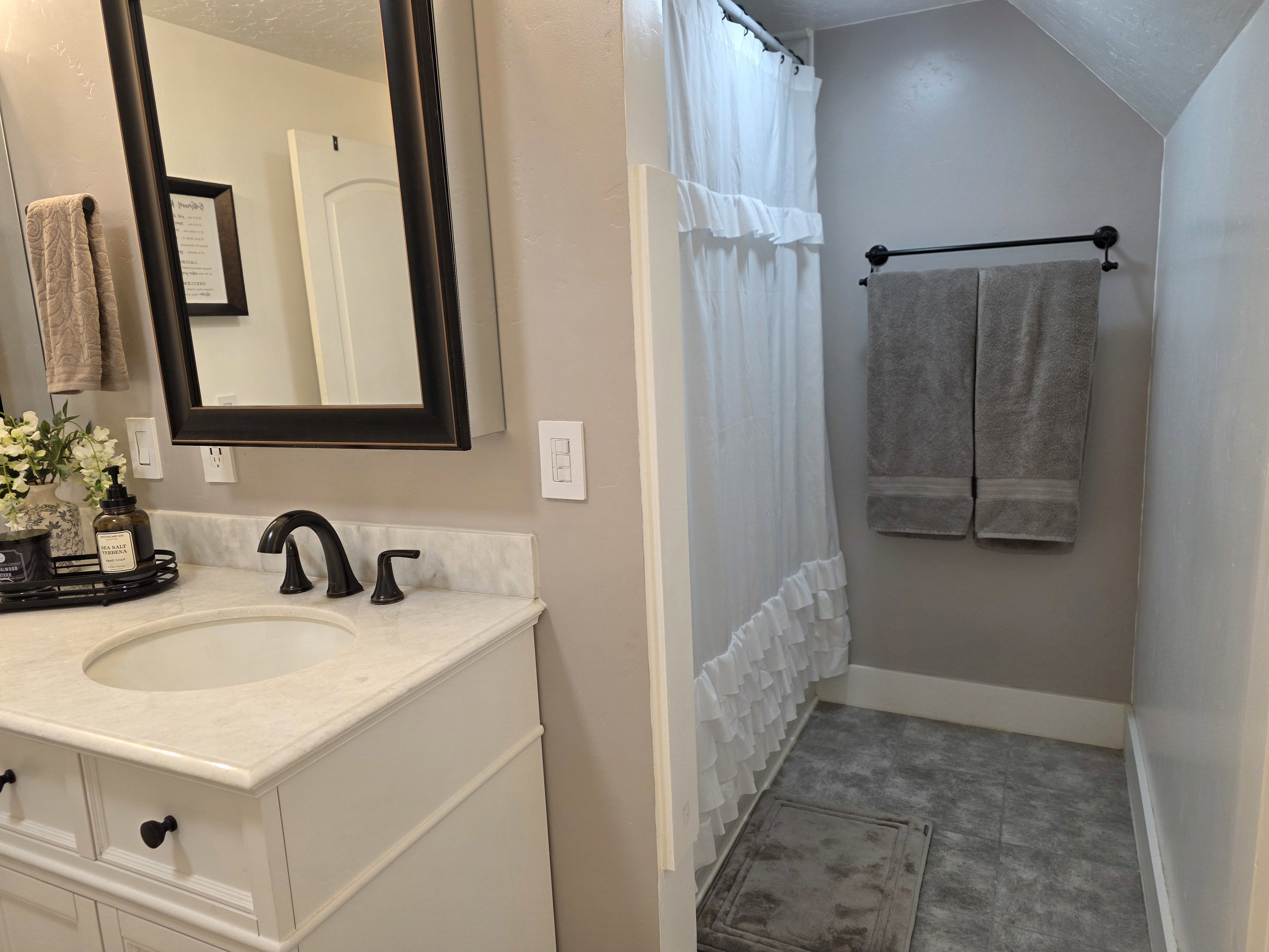 Full bath with vanity, a shower with curtain, and vaulted ceiling