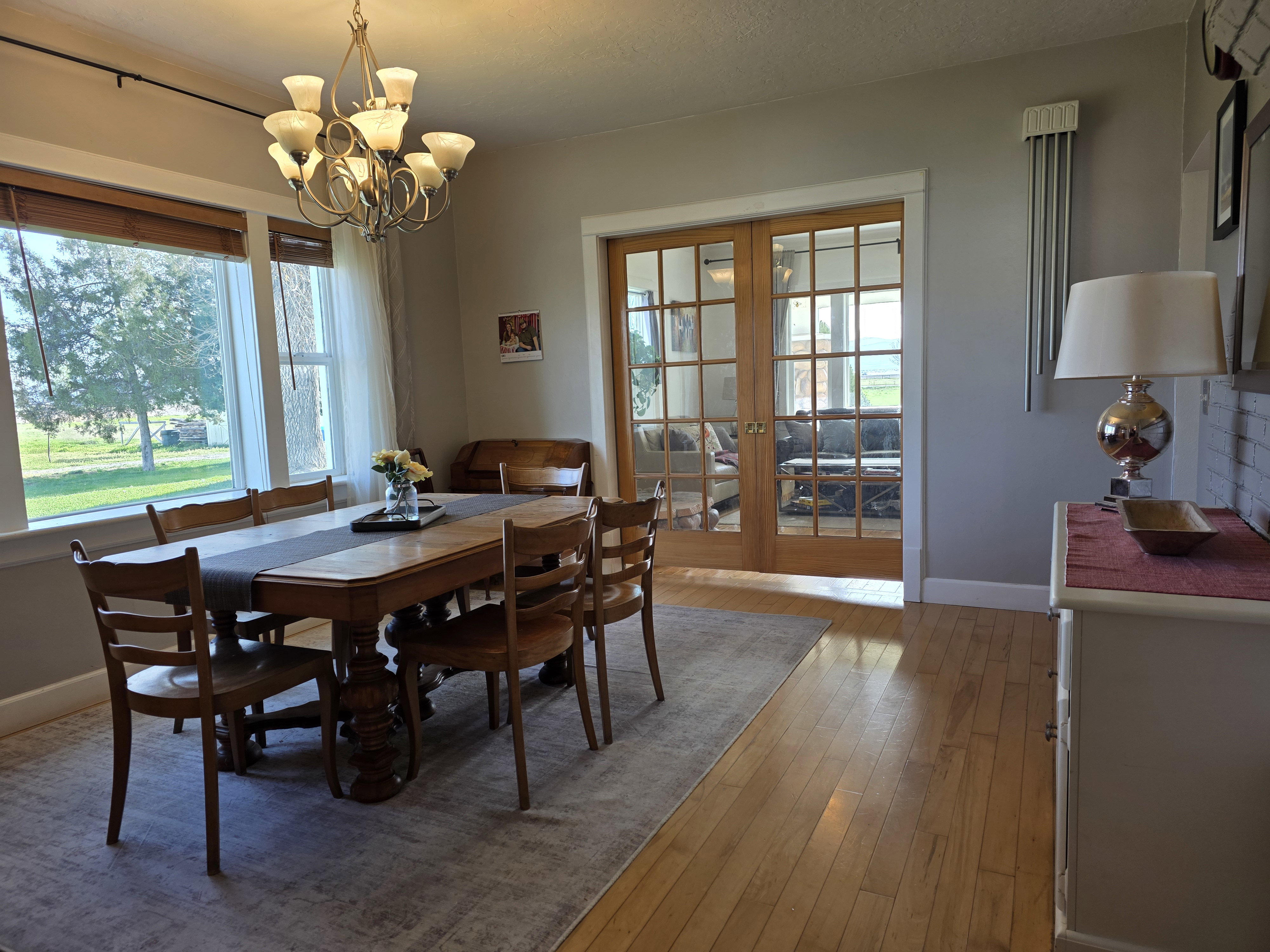 Dining space with french doors, light wood-style flooring, and suspended lighting