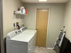 Laundry room with light wood-style floors and washer and dryer