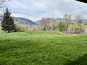 View of green lawn featuring a mountain view from lower level