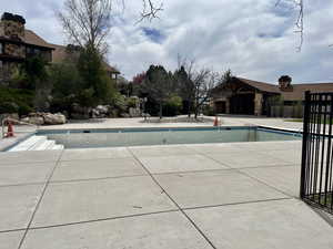 Fenced pool area with hot tub