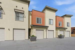 View of front of house featuring board and batten siding, a garage, and stucco siding