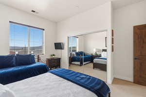 Bedroom featuring light colored carpet and a closet