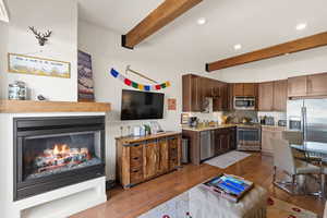 Kitchen with backsplash, stainless steel appliances, recessed lighting, dark wood-style flooring, and beam ceiling
