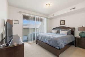 Bedroom with light carpet and access to exterior