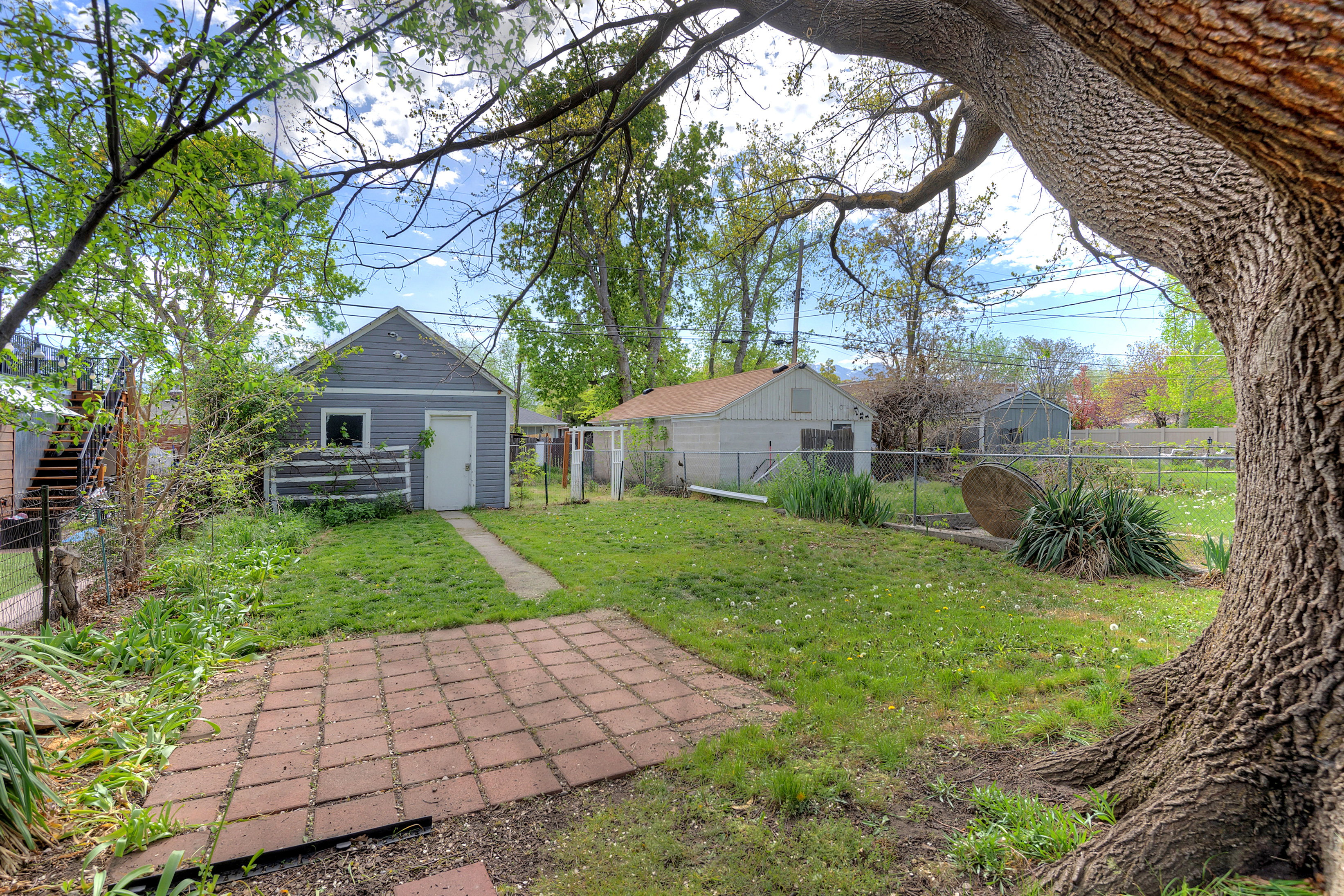 Fenced backyard featuring an outbuilding
