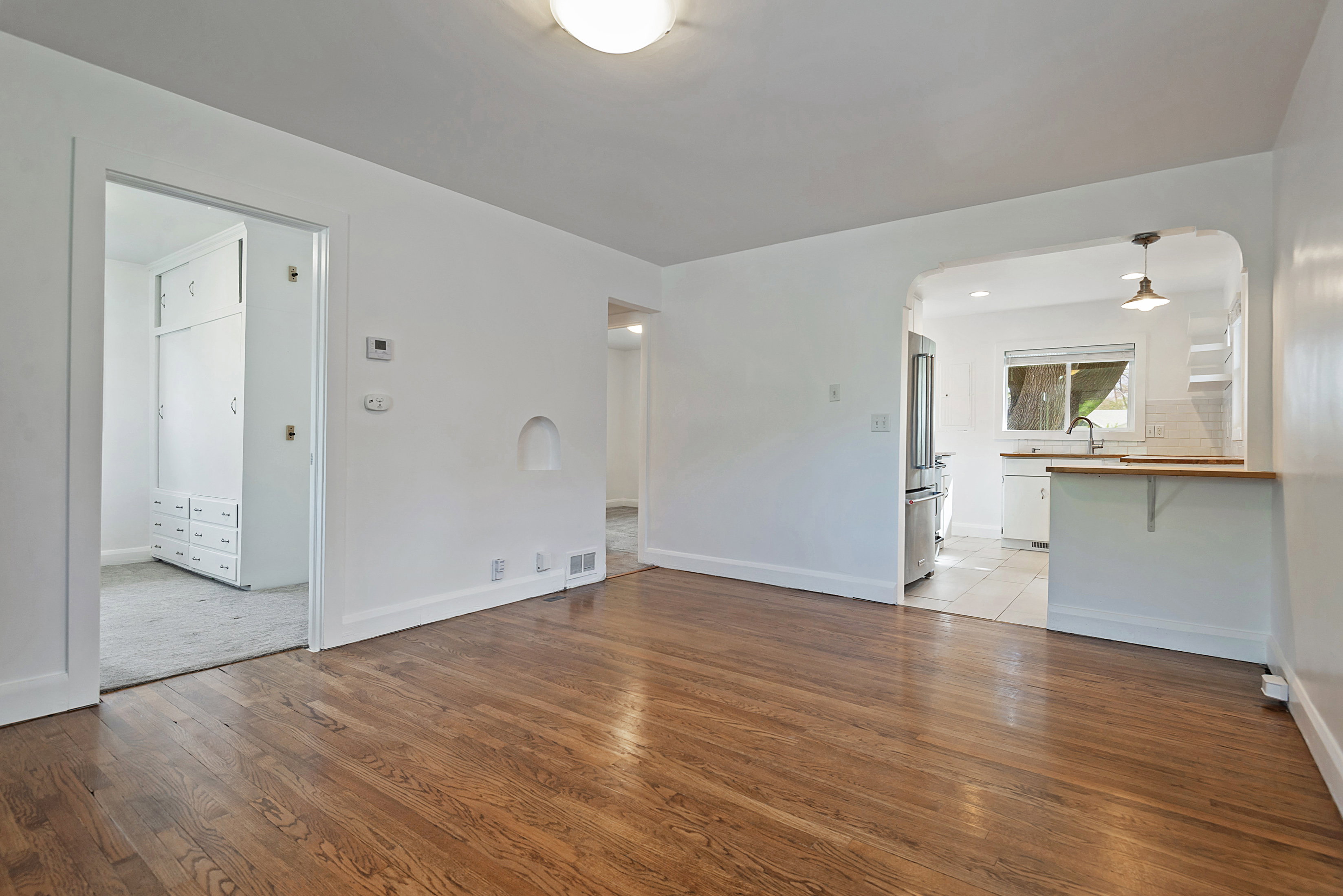 Unfurnished living room featuring light wood-style floors and arched walkways