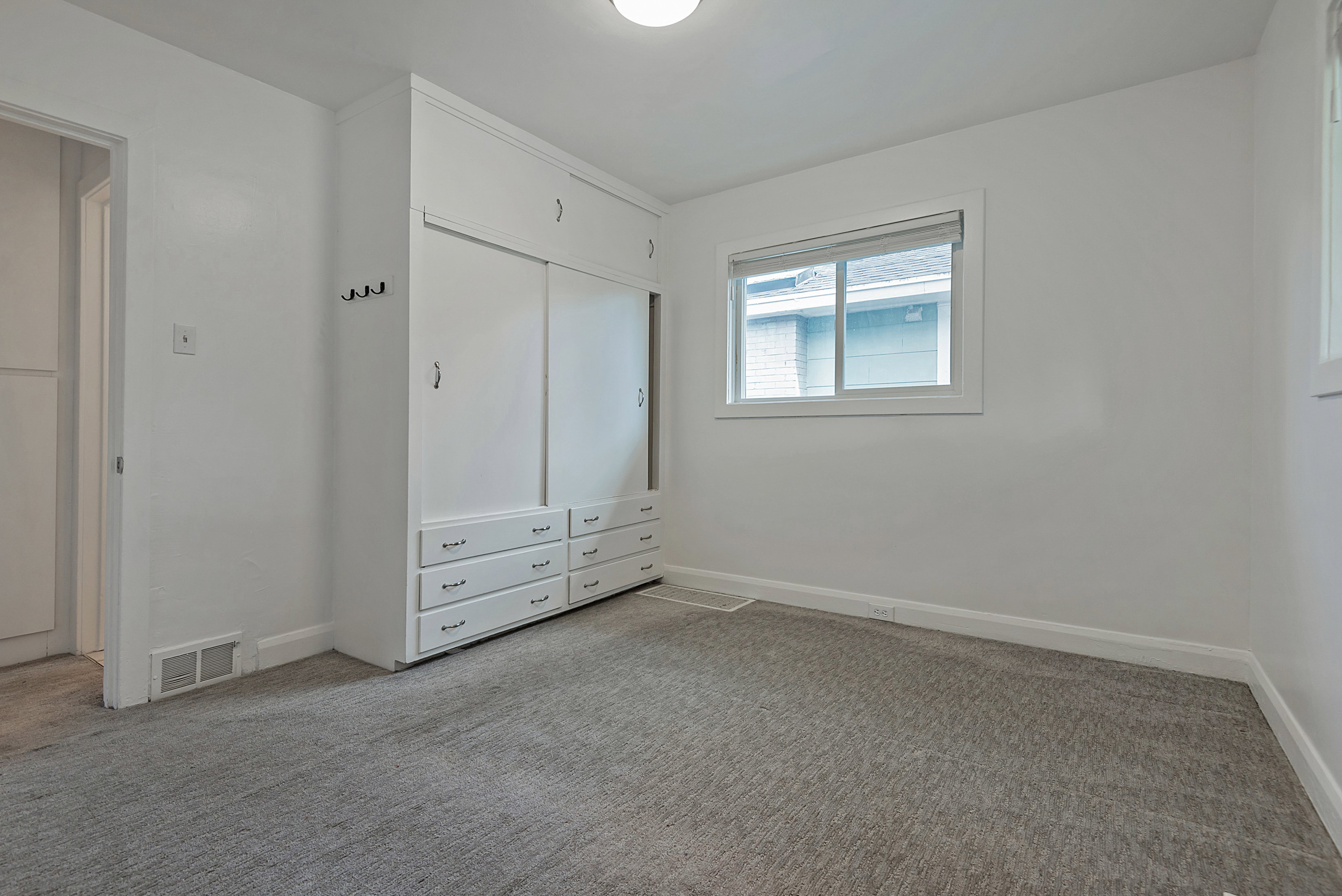 Unfurnished bedroom with light carpet and a closet
