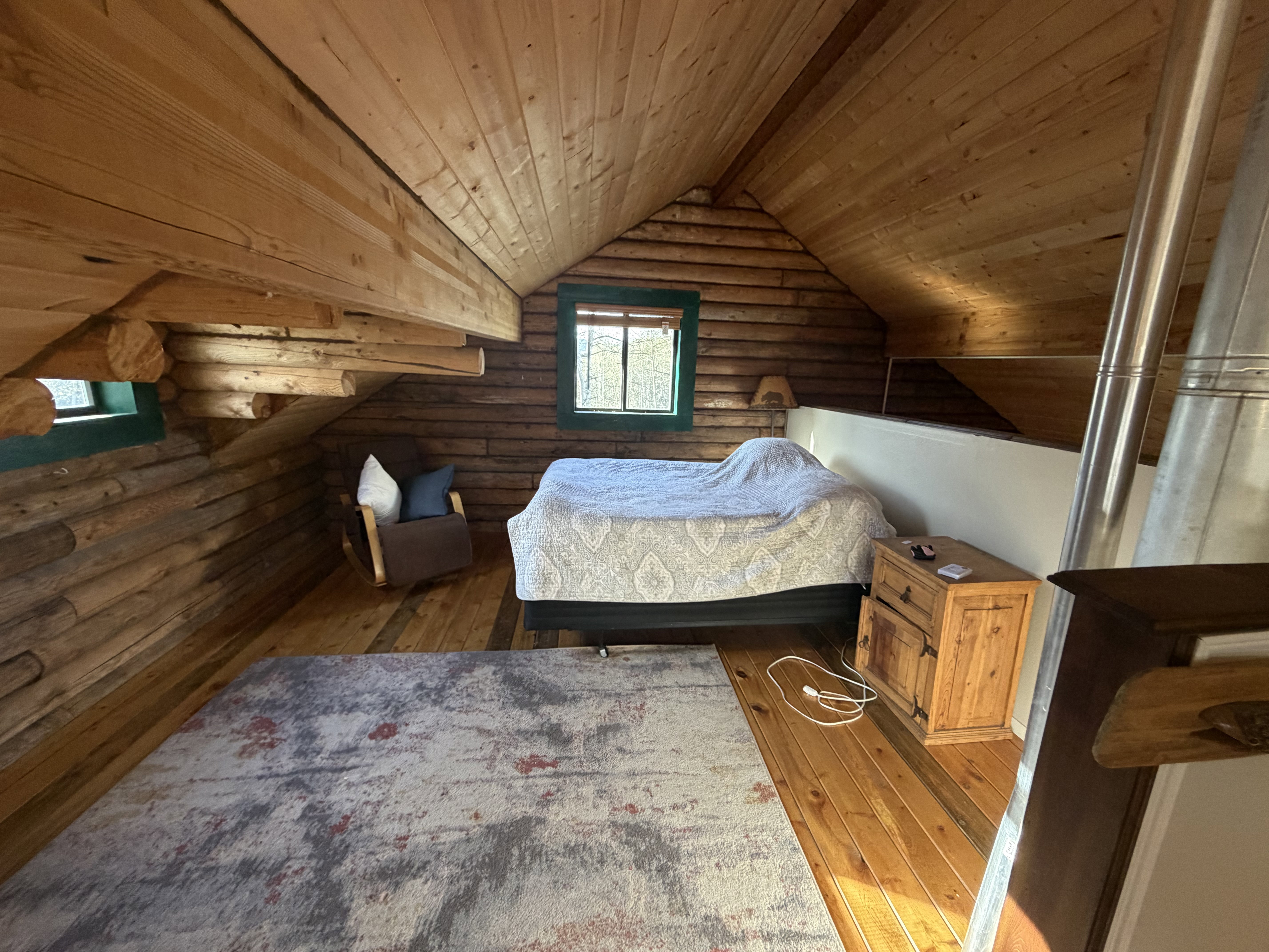 Bedroom with rustic walls, a vaulted wood ceiling, and wood-type flooring