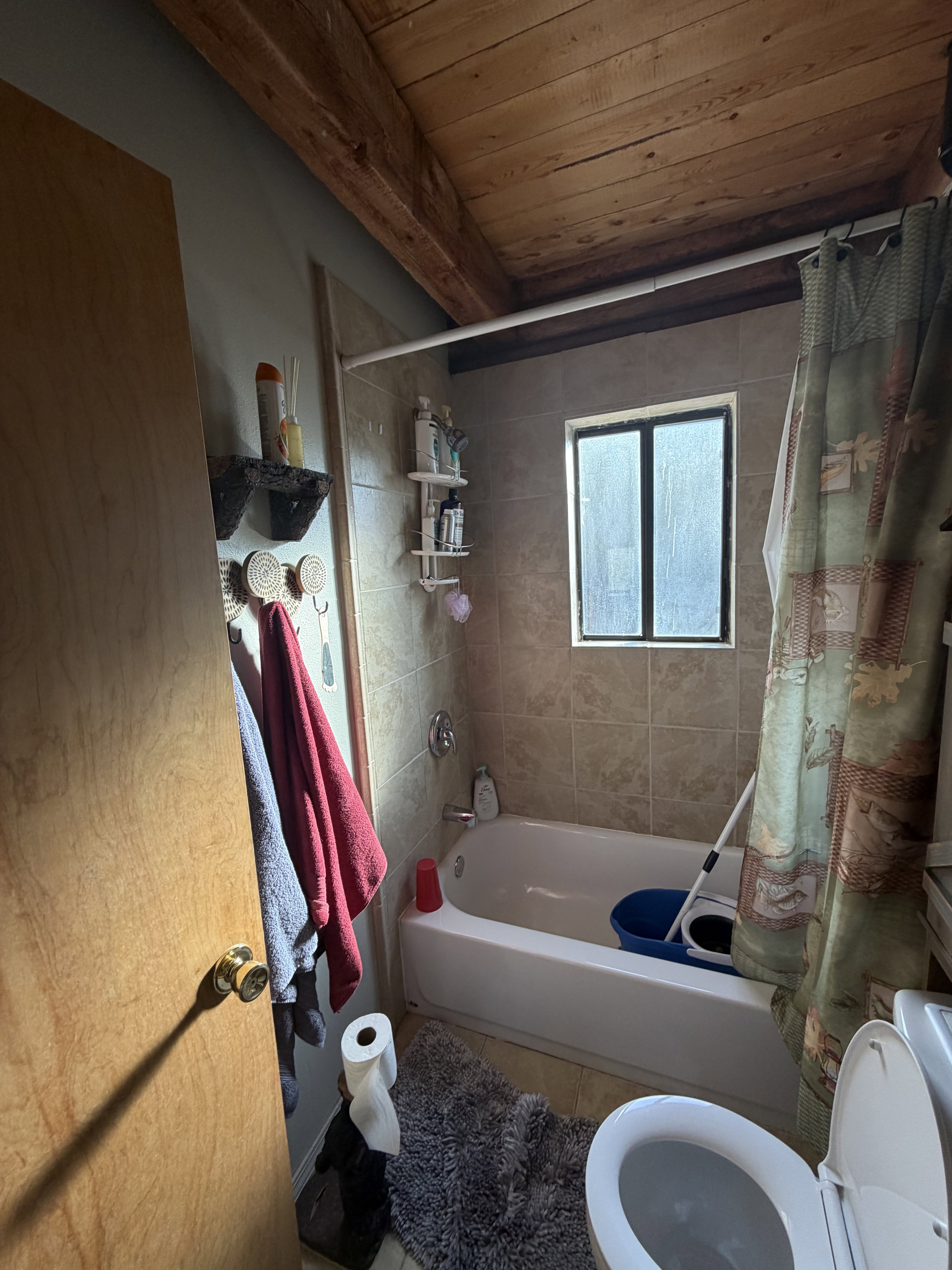 Bathroom featuring shower / tub combo with curtain, wood ceiling, and tile patterned floors